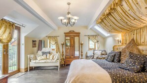 A bedroom with a large bed, a sofa, a wooden cabinet, and a chandelier. - 6 bedroom accommodation in Highley, near Bridgenorth (Highley, near Bridgenorth)