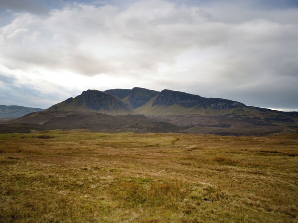 A mountainous landscape with a grassy foreground and a cloudy sky. - 2 bedroom accommodation in Ratagan, By Kyle of Lochalsh (Ratagan, By Kyle of Lochalsh)