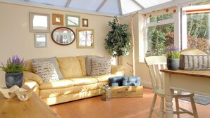 Una habitación acogedora con un sofá amarillo, una mesa de madera y una cesta de mimbre.