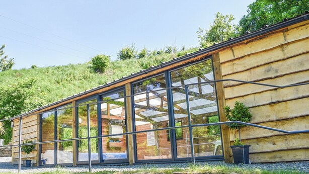 Ein modernes Gebäude mit großen Glasfenstern und einer Sockel aus Naturstein.