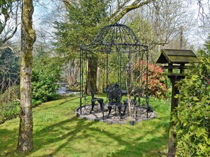 A garden with a gazebo, a swing set, and a birdhouse. - 1 bedroom accommodation in Dalbeattie, near Dumfries (Dalbeattie, near Dumfries)