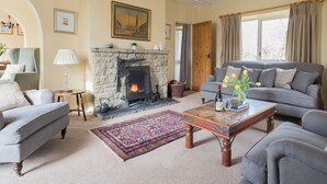 A living room with a fireplace, a sofa, a coffee table, and a patterned rug. - 3 bedroom accommodation in Pickering (Pickering)