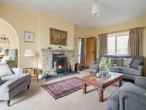 A living room with a fireplace, a sofa, a coffee table, and a patterned rug. - 3 bedroom accommodation in Pickering (Pickering)