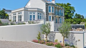 A two-story house with a white facade, multiple windows, and a balcony. - 8 bedroom accommodation in Porthpean, near Charlestown (Porthpean, near Charlestown)