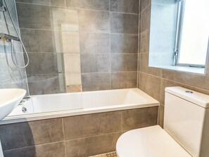 Une salle de bain avec une baignoire, des toilettes et un lavabo.