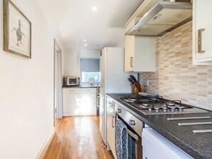 Une cuisine moderne équipée d’une cuisinière, d’un four à micro-ondes et de placards.