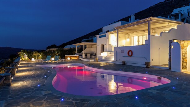 Une villa moderne dotée d’une piscine, de revêtements de sol en pierre et d’un espace salon extérieur.