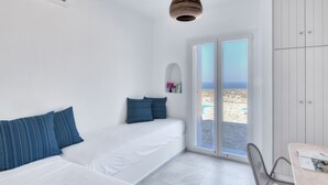 Une chambre d’hôtel moderne, équipée d’un lit, d’une chaise, d’une table et offrant une vue sur la plage.