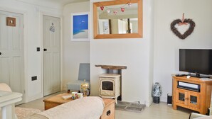 A living room with a television, a fireplace, a sofa, and a coffee table.