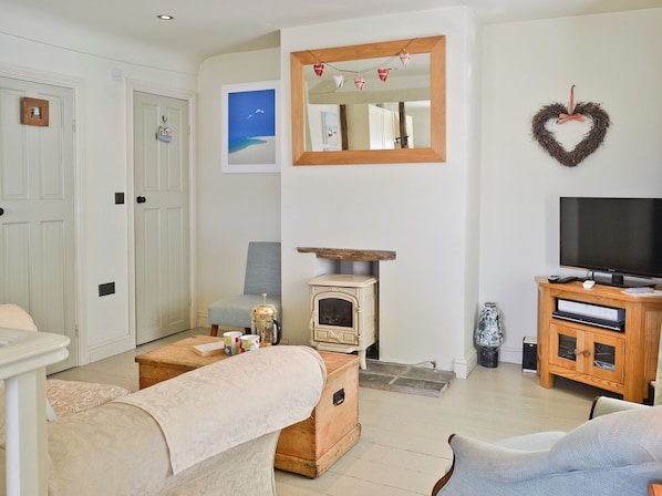 A living room with a television, a fireplace, a sofa, and a coffee table.