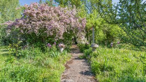 A garden pathway with flowering trees and a stone bench. - 3 bedroom accommodation in Callow End, Worcester (Callow End, Worcester)