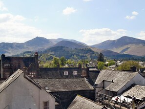 Une ville à l’architecture traditionnelle, avec une chaîne de montagnes en arrière-plan et un ciel dégagé.
