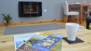 Ein Holztisch mit einer weißen Tasse, einem Untersetzer und Reisebroschüren.