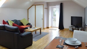 Ein modernes Wohnzimmer mit einer Couch, einem Couchtisch und einem Fernseher.
