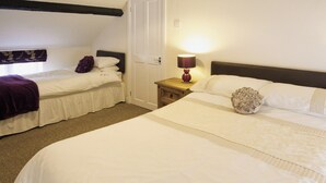 A hotel room with two single beds, a nightstand with a lamp, and a door. - Deuglawdd Cottage - HW7788 (Aberdaron, near Pwllheli)