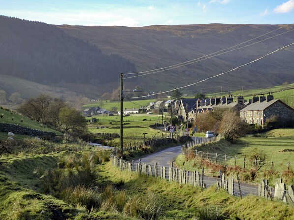 A rural road with stone houses and a stone wall.