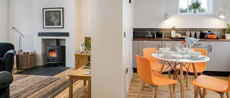A modern kitchen with a dining area, a fireplace, and a view of the outdoors.