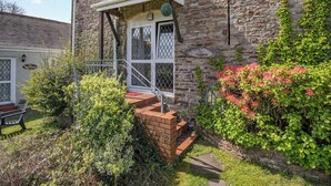 A stone building with a white door and a sign reading "TY YSGUBOR". - 2 bedroom accommodation in Gowerton, Gower (Gowerton, Gower)