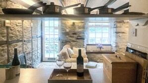 Una cucina accogliente con pareti in pietra, un piano di lavoro in legno e una finestra con vista.
