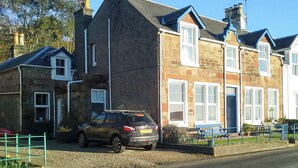 A row of stone houses with a car parked in front.