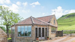 A stone house with a tiled roof, large windows, and a gravel driveway. - 2 bedroom accommodation in Swainby, near Stokesley (Swainby, near Stokesley)