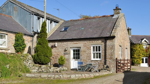 A stone house with a tiled roof, a small garden, and a wooden gate. - 1 bedroom accommodation in Once Brewed, Bardon Mill, near Hexham (Once Brewed, Bardon Mill, near Hexham)