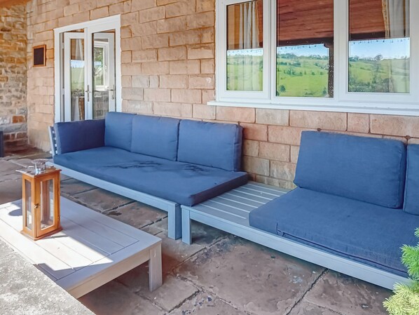 A stone building with a blue sofa and a wooden table.