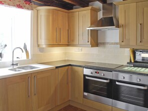 A kitchen with wooden cabinets, a stainless steel range, and a built-in oven. - 5 bedroom accommodation in Butterton (Butterton)