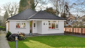 Einbungalow mit geneigtem Dach, einer Haustür und einer kleinen Veranda.