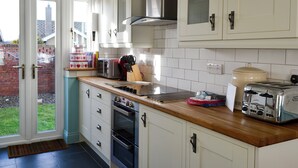 A kitchen with white cabinets, a stainless steel range hood, a toaster, and a kettle. - 3 bedroom accommodation in Beadnell (Beadnell)