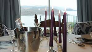 A table set for dining with a view of a lake and mountains.