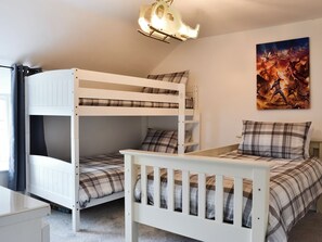 A bunk bed room with a ceiling light fixture and a wall painting.