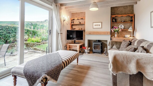 A spacious living room with a large window, a fireplace, a television, and a cozy seating area. - 4 bedroom accommodation in Rosedale Abbey (Rosedale Abbey)