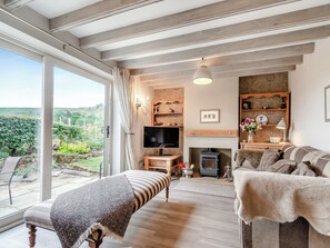 A spacious living room with a large window, a fireplace, a television, and a cozy seating area. - 4 bedroom accommodation in Rosedale Abbey (Rosedale Abbey)