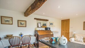 A cozy kitchen with wooden chairs, a dining table, and a coffee station. - Castle House Cottage (Hartley, near Kirkby Stephen)