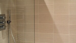 Un baño con bañera, ducha con cabezal de ducha manual y grifo empotrado.