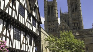 A historic building with timber framing and a large Gothic cathedral in the background. - 2 bedroom accommodation in West Ashby, near Horncastle (West Ashby, near Horncastle)
