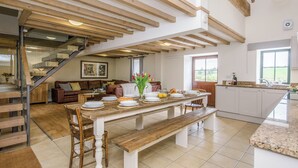A spacious kitchen with a dining area, wooden beams, a staircase, and a view of the outdoors. - 7 bedroom accommodation in Bradbourne, near Ashbourne (Bradbourne, near Ashbourne)