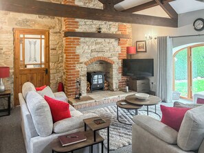 A cozy living room with a stone fireplace, a television, and comfortable seating. - 2 bedroom accommodation in Shotley Bridge (Shotley Bridge)