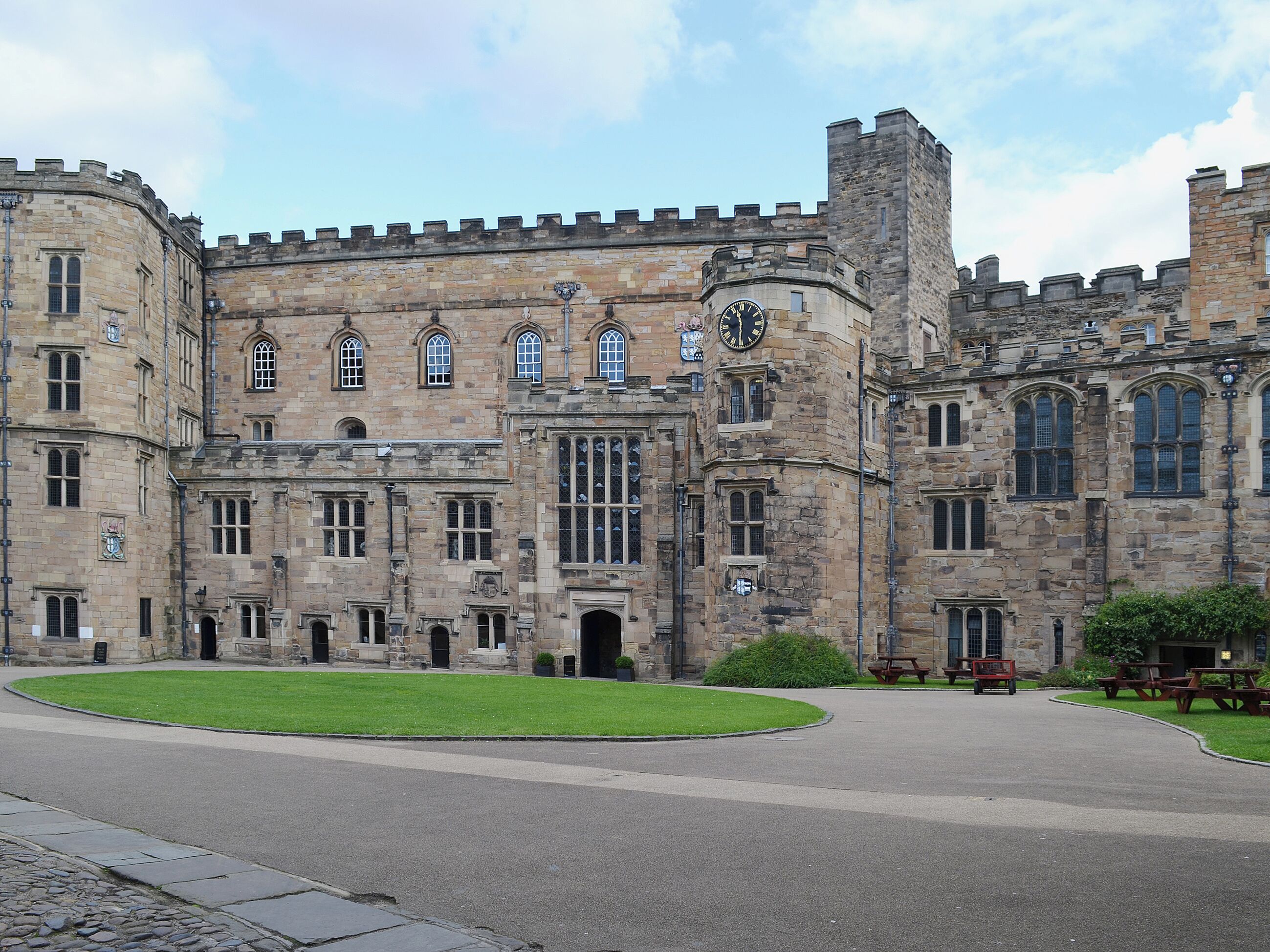 A historic stone building with large windows and a central clock tower.