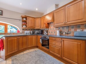 A kitchen with wooden cabinets, a microwave, a kettle, and a toaster. - 2 bedroom accommodation in Shotley Bridge (Shotley Bridge)