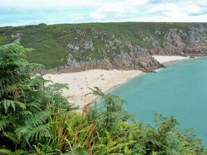A coastal beach with rocky cliffs and dense greenery. - 4 bedroom accommodation in Sennen (Sennen)