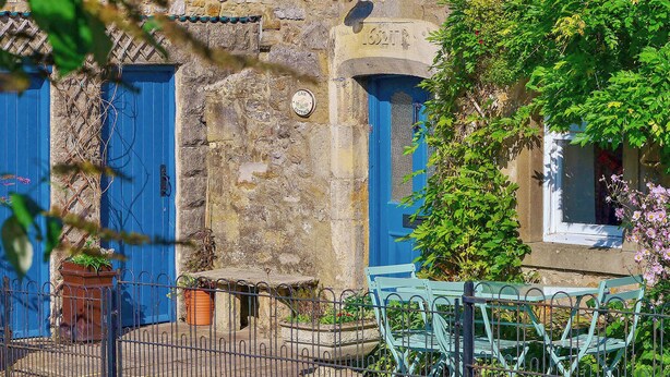 A stone building with blue doors, a metal fence, and outdoor furniture. - 3 bedroom accommodation in Kettlewell, near Grassington (Kettlewell, near Grassington)