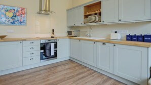 A modern kitchen with white cabinets, a built-in oven, a microwave, and a sink. - The Stables at Weedon Hill Farm (Weedon, near Daventry)