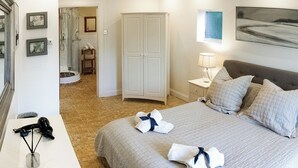 Hotelkamer met een bed, nachtkastje, lamp, kledingkast en een badkamer met douche en toilet.