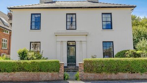 A two-story building with a symmetrical facade, a central entrance, and a brick wall with a gate. - 3 bedroom accommodation in Filey (Filey)