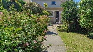 Una casa residencial con un camino pavimentado que conduce a la entrada.