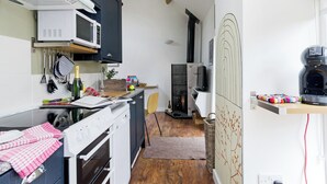 Une cuisine compacte équipée d’un four à micro-ondes, d’un four traditionnel et d’une machine à café.