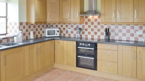 A kitchen with wooden cabinets, a microwave, a toaster, and a double oven.