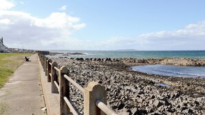 A rocky shoreline with a concrete walkway and railing. - 2 bedroom accommodation in Buckie, near Cullen (Buckie, near Cullen)